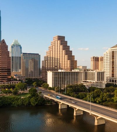 A bridge over a body of water with a city in the background