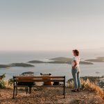 A person sitting on a bench next to a body of water
