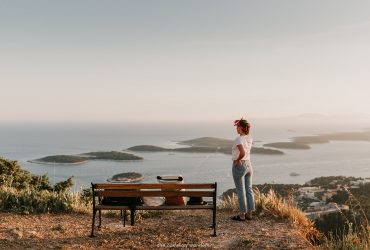 A person sitting on a bench next to a body of water